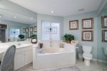Master bathroom offers a walk-in shower, dual vanities, and soaking tub.